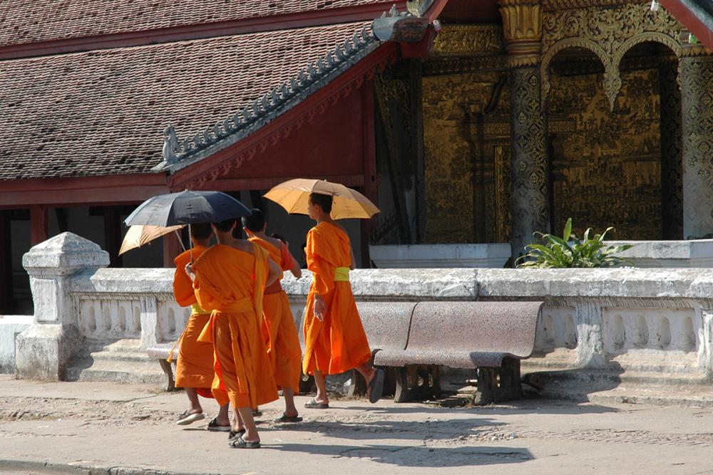 Monks passing by the Vat Mai temple in Luang Prabang